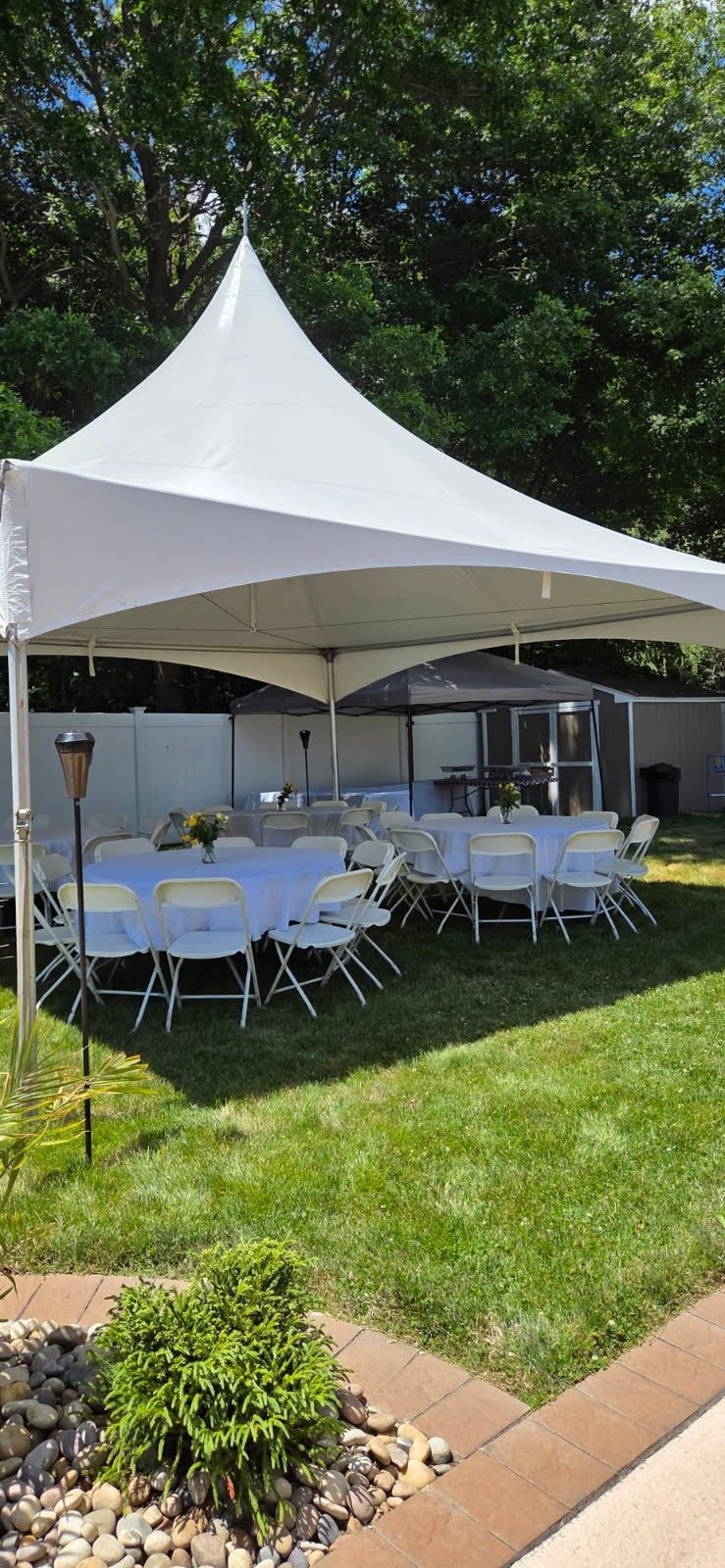 20×20 high-peak tent over round tables with white linens